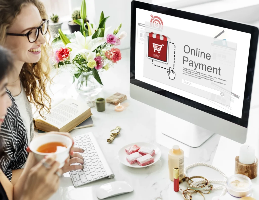 Due donne sorridenti discutono davanti a un computer che mostra la scritta 'Equal Pay', concetto collegato al cambiamento nelle pratiche finanziarie innovative come il Buy Now Pay Later e-commerce, che offre soluzioni flessibili per gli acquisti online.